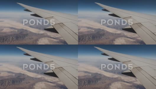从飞机窗户上方以飞行高度观赏岩石构造的翼和沙漠景象高清在线视频素材下载