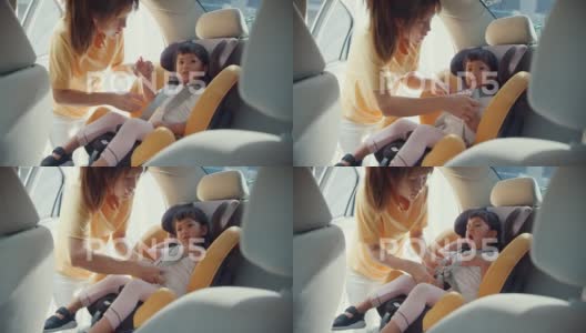 妈妈在开车前系好儿童汽车座椅安全带高清在线视频素材下载