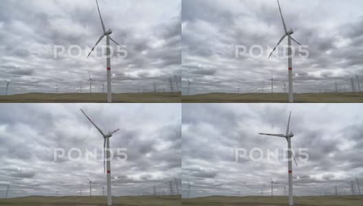 在田野背景下移动大型风力涡轮机的叶片高清在线视频素材下载
