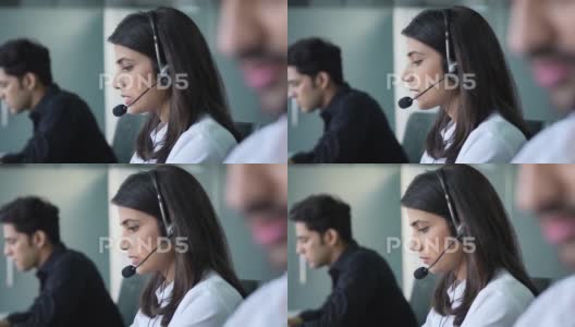 印度客服人员戴着麦克风耳机在呼叫中心工作。高清在线视频素材下载