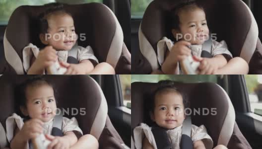 小女婴坐在汽车座椅上透过窗户看，开心的婴儿宝宝高清在线视频素材下载