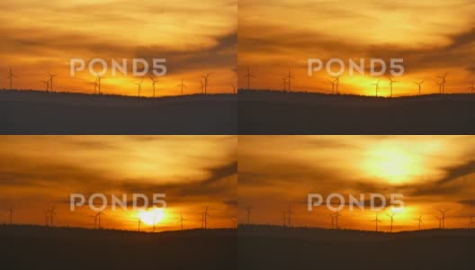 电动风力涡轮机在日出时的农场剪影。高清在线视频素材下载