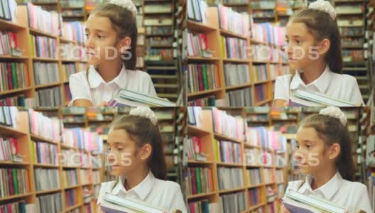 一个8-12岁女孩的肖像，站在图书馆里。一个书架高清在线视频素材下载