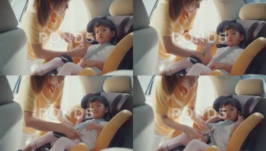 妈妈给孩子系好儿童汽车座椅安全带高清在线视频素材下载