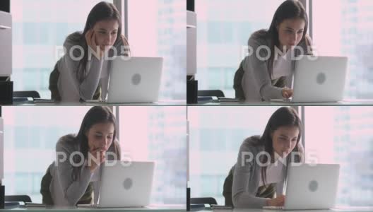 年轻美丽的女商人站在办公桌前使用笔记本电脑高清在线视频素材下载