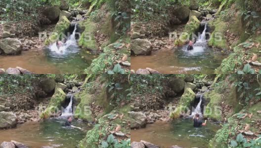 一个人跳进了一个小瀑布底部的小池塘4K高清在线视频素材下载