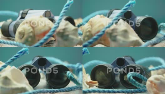 海贝壳和蓝黑双筒望远镜特写产品视频高清在线视频素材下载