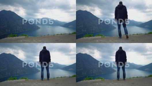 男人站在山顶凝望湖泊高清在线视频素材下载