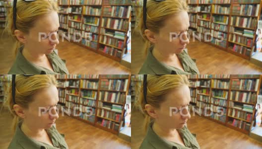 一位站在图书馆里的女性肖像，背景是书架4K高清在线视频素材下载
