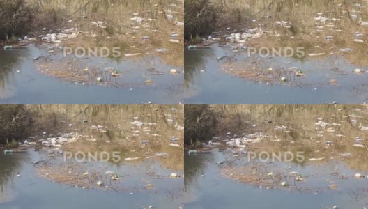 漂浮在河面上的塑料瓶和其他垃圾。高清在线视频素材下载