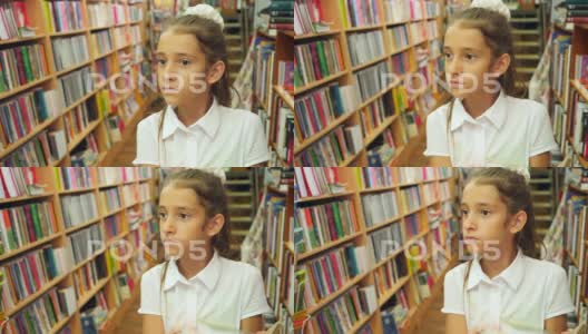 一个8-12岁女孩的肖像，站在图书馆里。一个书架高清在线视频素材下载