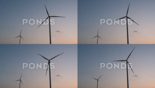 能源的未来、可再生能源的象征在日落时分，风力涡轮机的剪影映衬在蓝天下，显得干净而美丽高清在线视频素材下载
