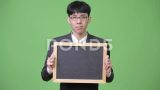 年轻的亚洲商人对着镜头展示黑板高清在线视频素材下载