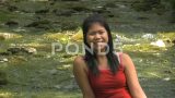 春天，穿着红色连衣裙的亚洲女人坐在河边高清在线视频素材下载