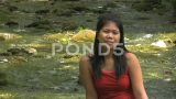 春天，穿着红色连衣裙的亚洲女人坐在河边高清在线视频素材下载
