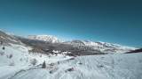 FPV无人机从山顶俯瞰积雪的山峰高清在线视频素材下载