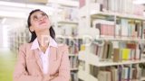 女人站在图书馆里思考高清在线视频素材下载