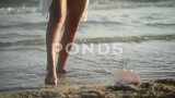 日落时分，女人在海水上跳舞的腿特写高清在线视频素材下载