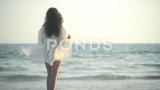 快乐的女人黑发在一个白色Pareo看欣赏日落的夜晚海高清在线视频素材下载