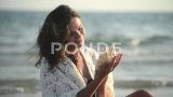 女人黑发听一个大美丽的海贝微风附近的耳朵高清在线视频素材下载