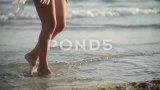 日落时分，女人在海水上跳舞的腿特写高清在线视频素材下载