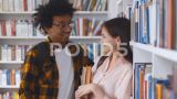 年轻的多民族夫妇站在大学图书馆的书架前高清在线视频素材下载