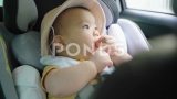 亚洲婴儿男孩坐在汽车座椅上开心玩耍高清在线视频素材下载